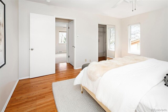 bedroom with light wood finished floors, ceiling fan, and baseboards