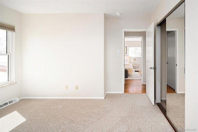 unfurnished bedroom featuring carpet floors, visible vents, and baseboards