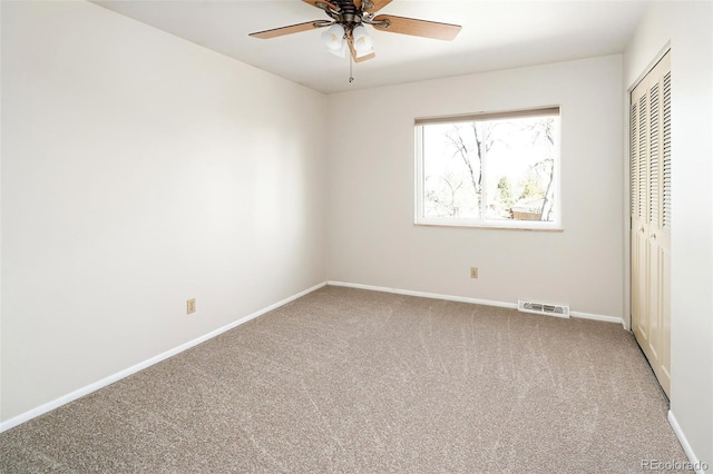 unfurnished bedroom with ceiling fan, carpet floors, visible vents, baseboards, and a closet