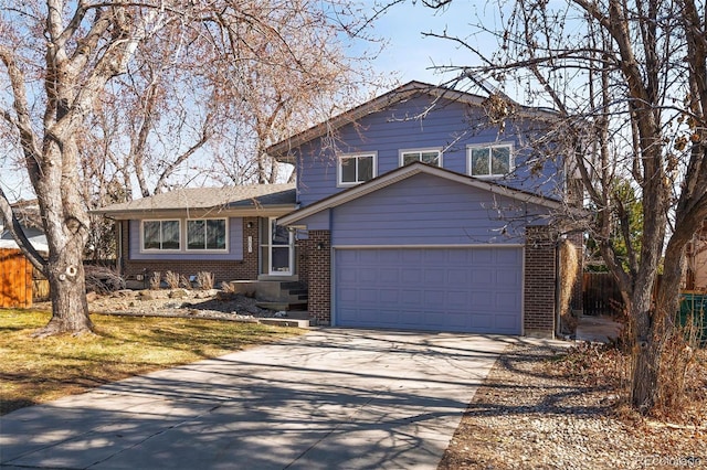 tri-level home featuring a garage, concrete driveway, brick siding, and fence