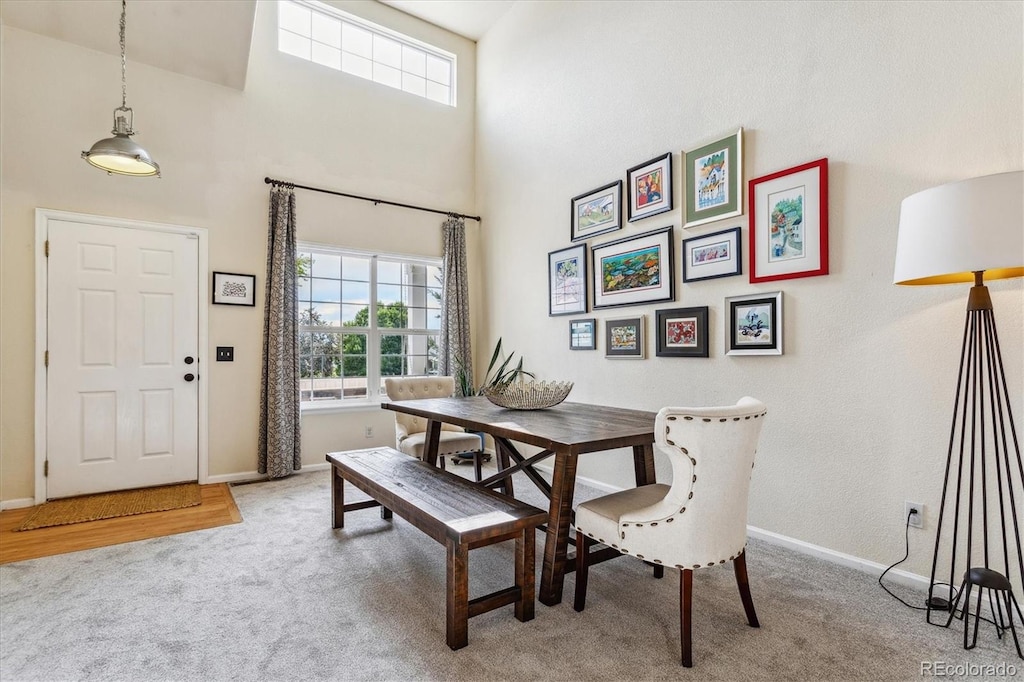 dining room featuring a high ceiling and carpet