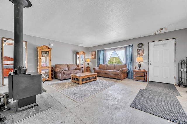 21494 Way Of Peace, Deer Trail, CO 80105 - living room featuring a wood stove, a textured ceiling, and concrete flooring