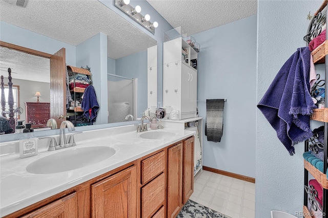 21494 Way Of Peace, Deer Trail, CO 80105 - bathroom featuring tile patterned floors, a textured ceiling, a stall shower, and double vanity