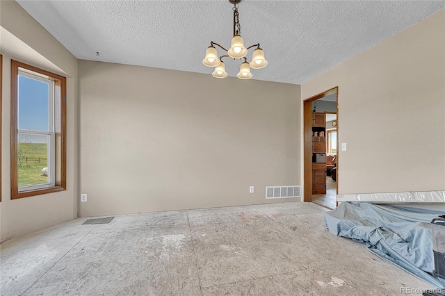 21494 Way Of Peace, Deer Trail, CO 80105 - empty room featuring a chandelier, healthy amount of natural light, and a textured ceiling