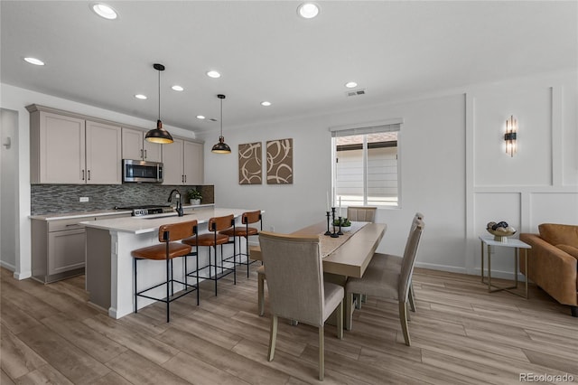 dining area featuring light wood finished floors, visible vents, and recessed lighting