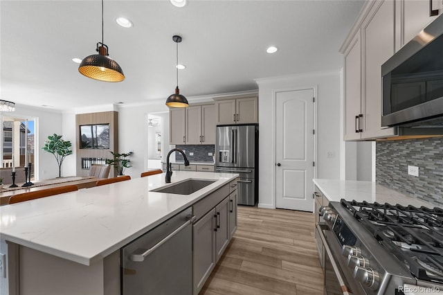 kitchen featuring recessed lighting, gray cabinetry, appliances with stainless steel finishes, and a sink