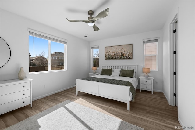 bedroom with baseboards, a ceiling fan, and wood finished floors