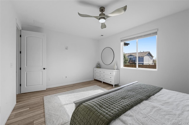bedroom with baseboards, ceiling fan, and wood finished floors