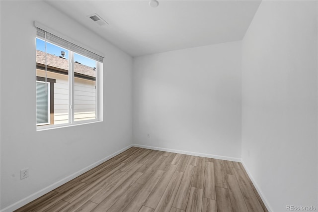 spare room featuring visible vents, wood finished floors, and baseboards
