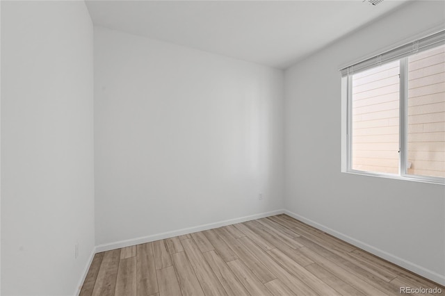 empty room with light wood-type flooring and baseboards