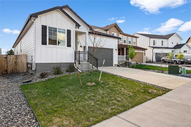 view of front facade featuring board and batten siding, driveway, fence, a garage, and a front yard