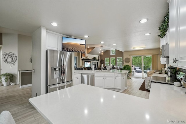 7548 S Biloxi Way, Aurora, CO 80016 - kitchen with appliances with stainless steel finishes, a peninsula, white cabinets, recessed lighting, and open floor plan