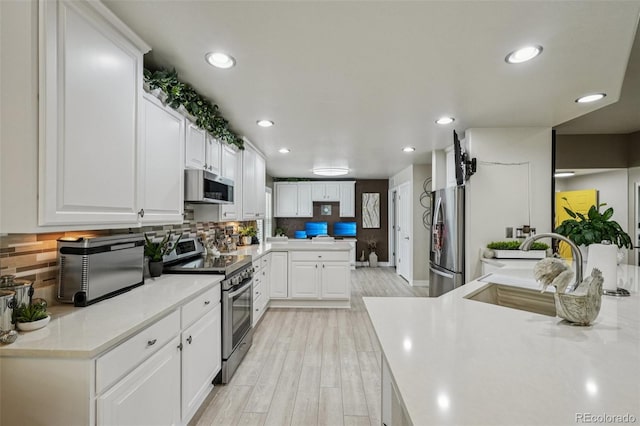 7548 S Biloxi Way, Aurora, CO 80016 - kitchen featuring stainless steel appliances, light wood-style floors, white cabinetry, tasteful backsplash, and light countertops