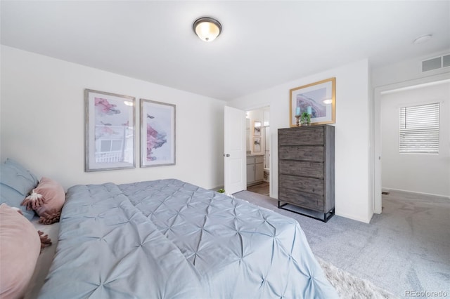 bedroom with connected bathroom and carpet floors