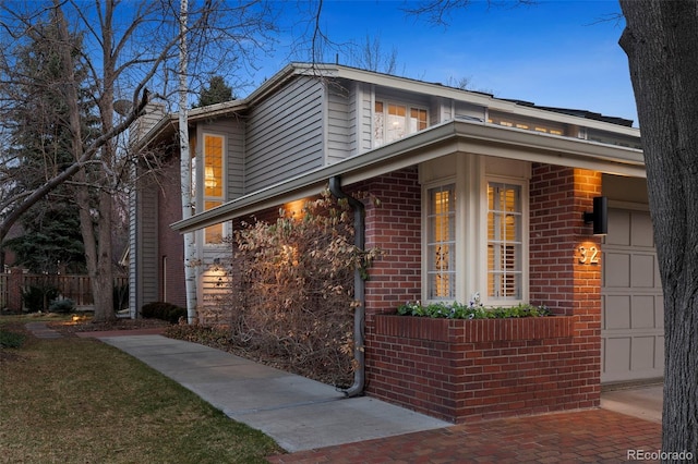 view of side of property with brick siding and a garage