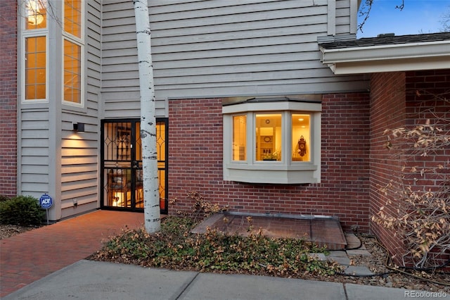 doorway to property with brick siding