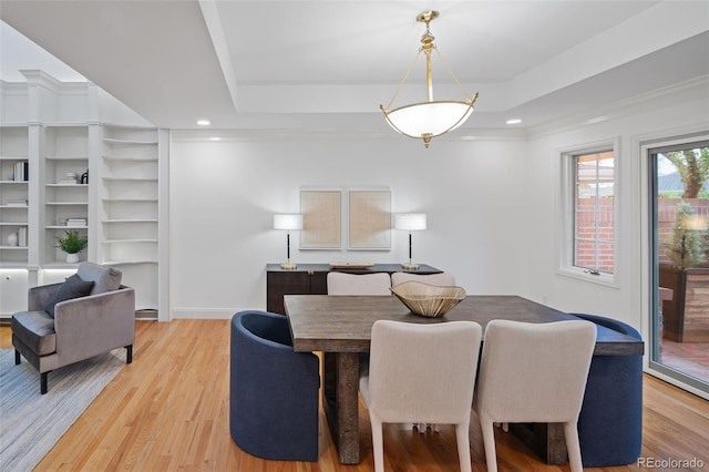 dining space with light wood-style flooring, a tray ceiling, baseboards, and recessed lighting
