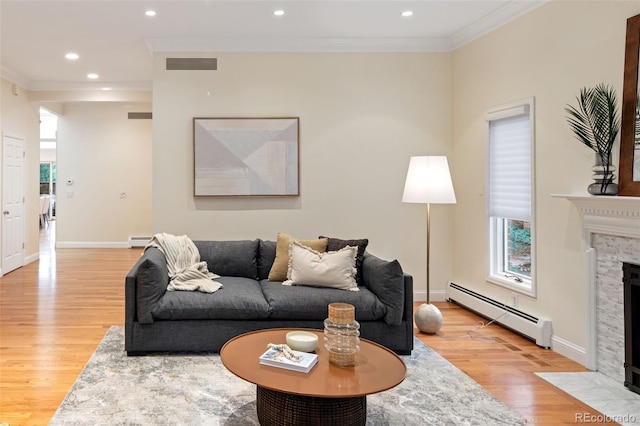 living area with a baseboard heating unit, light wood-style floors, baseboard heating, a fireplace with flush hearth, and ornamental molding