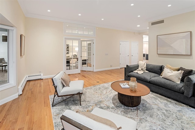 living area with a baseboard heating unit, light wood-style floors, recessed lighting, ornamental molding, and baseboards