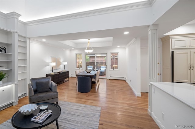 living room with a baseboard radiator, a raised ceiling, ornamental molding, light wood-style floors, and baseboards