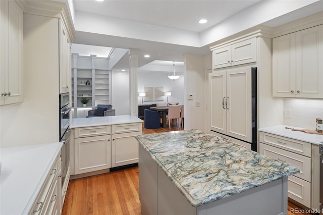 kitchen with light wood-style flooring, recessed lighting, a center island, stainless steel oven, and a peninsula