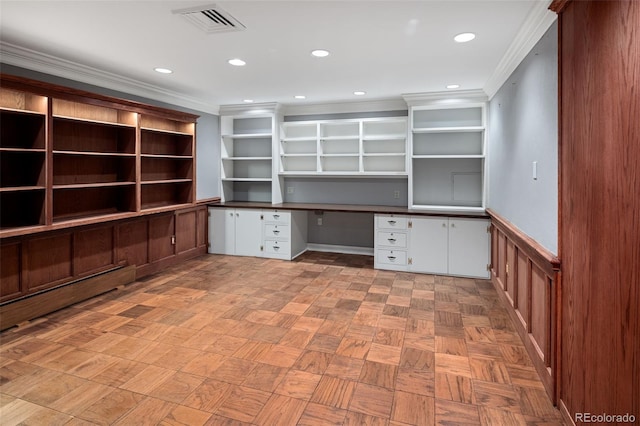 unfurnished office with built in desk, ornamental molding, a wainscoted wall, and recessed lighting