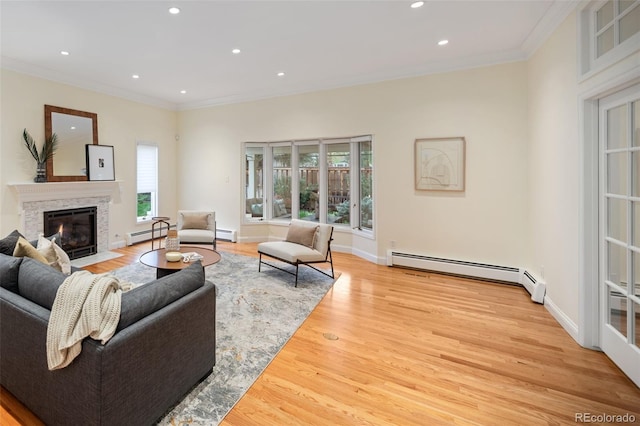 living room featuring baseboard heating, ornamental molding, healthy amount of natural light, light wood-type flooring, and recessed lighting