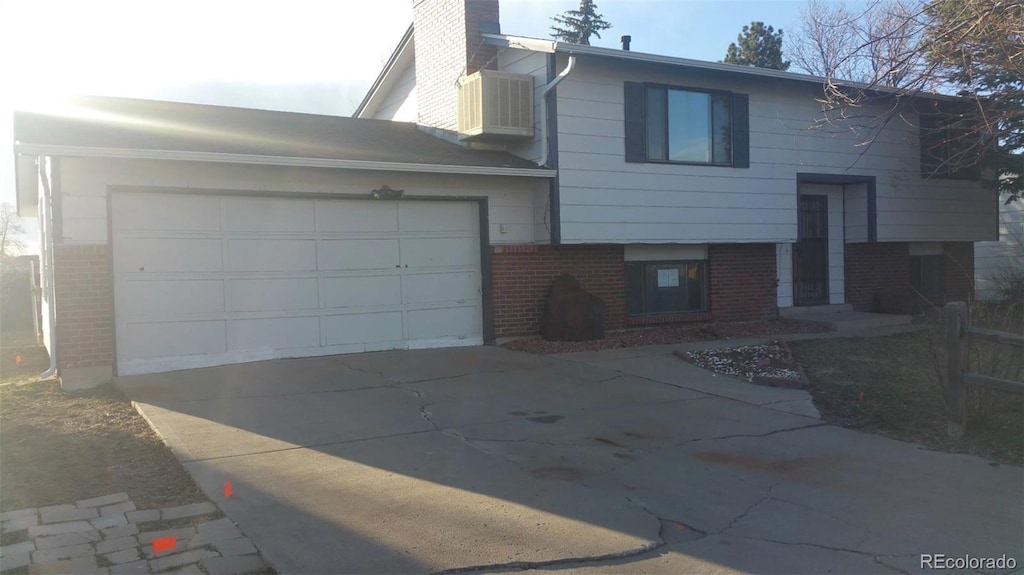 view of front facade with cooling unit and a garage