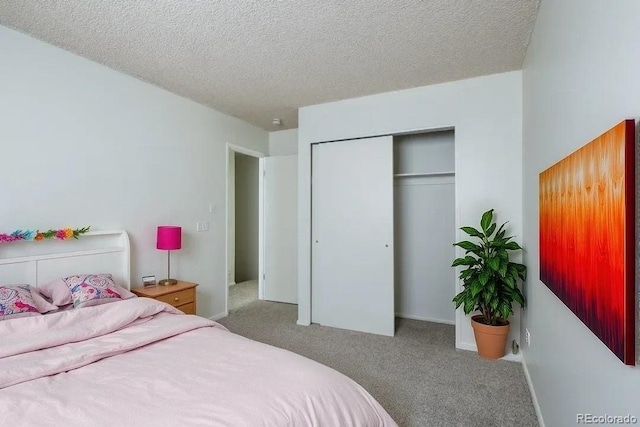 carpeted bedroom featuring a closet and a textured ceiling