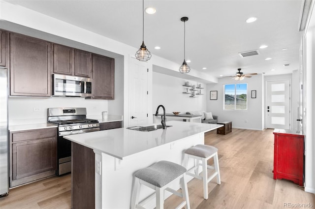 22826 E Tufts Pl Unit A, Aurora, CO 80015 - kitchen with appliances with stainless steel finishes, open floor plan, light countertops, recessed lighting, and light wood-style floors
