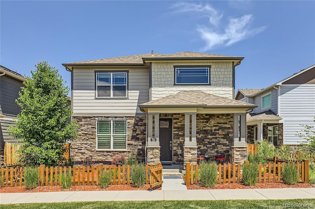 764 N Quatar St, Aurora, CO 80018 - view of front facade featuring stone siding, a fenced front yard, and roof with shingles