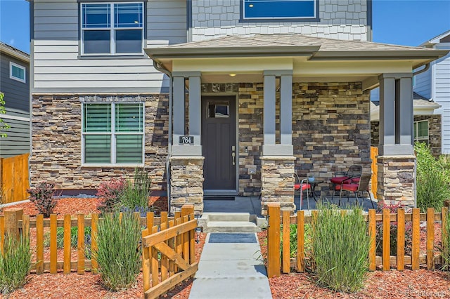 764 N Quatar St, Aurora, CO 80018 - doorway to property with stone siding and covered porch
