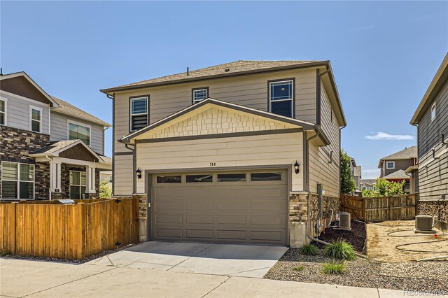 764 N Quatar St, Aurora, CO 80018 - view of front of house featuring driveway, stone siding, and a garage