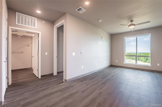 empty room featuring dark wood-type flooring and ceiling fan