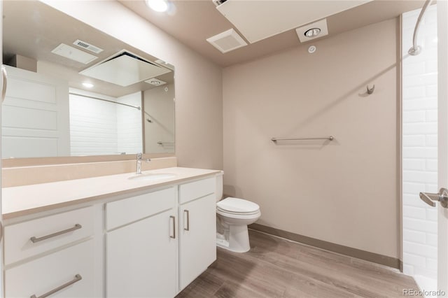 bathroom featuring toilet, vanity, hardwood / wood-style floors, and walk in shower