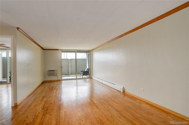 unfurnished room featuring crown molding, baseboard heating, floor to ceiling windows, a wall mounted air conditioner, and light wood-type flooring