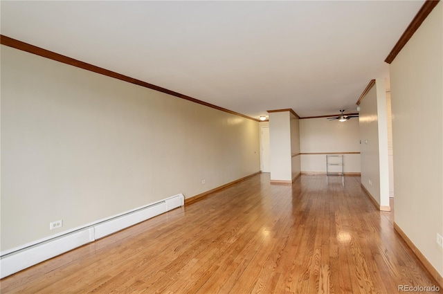 spare room featuring a baseboard heating unit, ornamental molding, ceiling fan, and light wood-type flooring