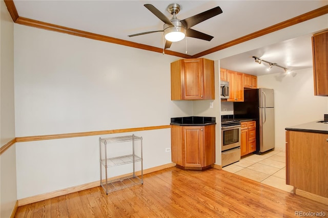 kitchen featuring light wood-type flooring, ornamental molding, ceiling fan, and appliances with stainless steel finishes