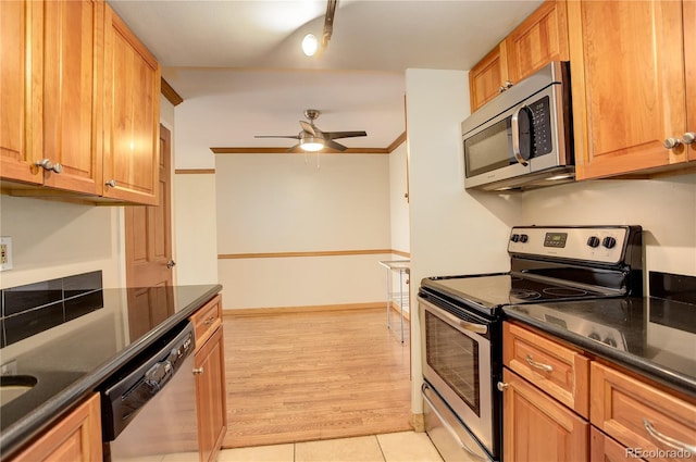 kitchen featuring ceiling fan, ornamental molding, appliances with stainless steel finishes, and light tile patterned flooring