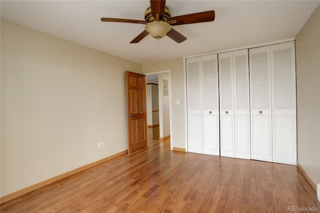 unfurnished bedroom with ceiling fan, light wood-type flooring, and a closet