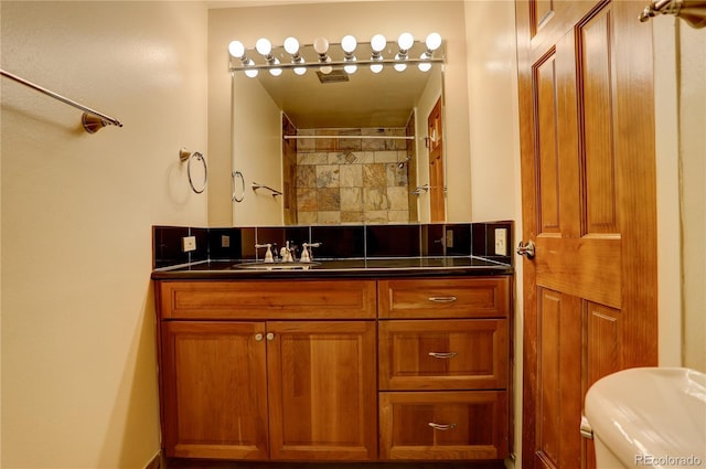 bathroom featuring walk in shower, vanity, and toilet