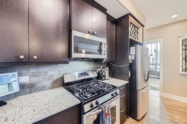 2001 Lincoln St Unit 2213, Denver, CO 80202 - kitchen with stainless steel appliances, dark brown cabinetry, decorative backsplash, and light wood-style flooring