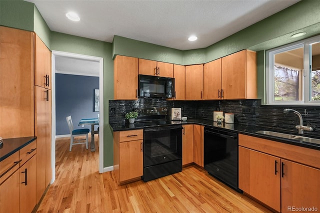 kitchen featuring black appliances, tasteful backsplash, a sink, light wood-style floors, and a textured ceiling