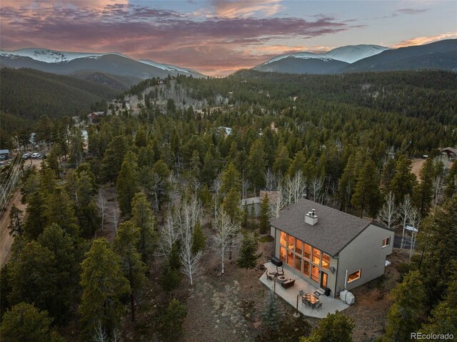 381 Highlands Dr, Bailey, CO 80421 - aerial view at dusk featuring a wooded view and a mountain view