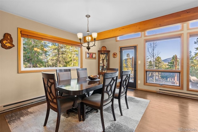 381 Highlands Dr, Bailey, CO 80421 - dining area with wood finished floors, a baseboard radiator, and a notable chandelier