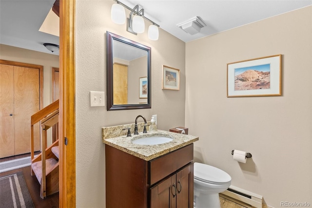 381 Highlands Dr, Bailey, CO 80421 - half bath featuring toilet, wood finished floors, visible vents, a baseboard heating unit, and vanity