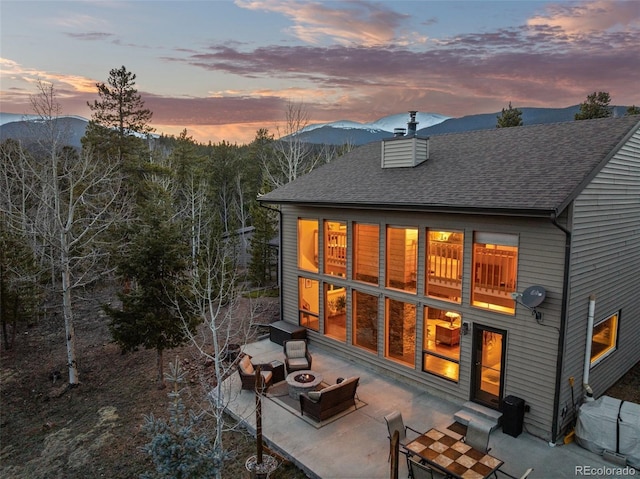 381 Highlands Dr, Bailey, CO 80421 - rear view of house featuring a patio, a fire pit, a chimney, roof with shingles, and entry steps