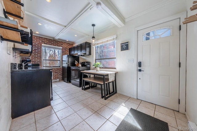 kitchen featuring baseboards, brick wall, black appliances, dark countertops, and beam ceiling