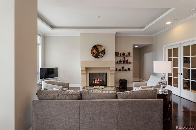 living room featuring a raised ceiling, dark hardwood / wood-style floors, french doors, and crown molding