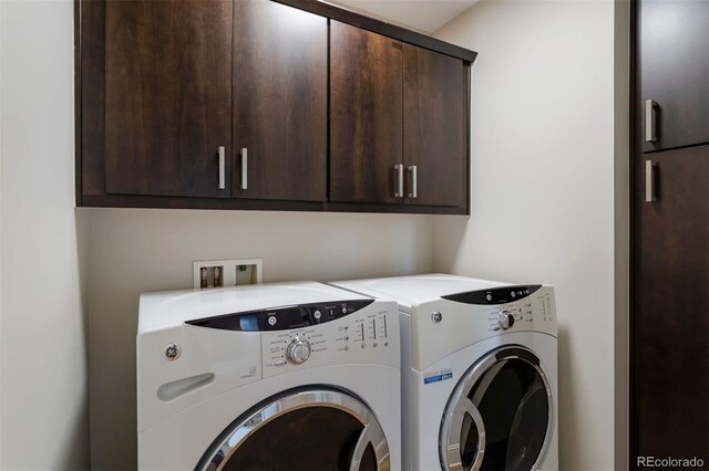 washroom featuring cabinets and washing machine and clothes dryer